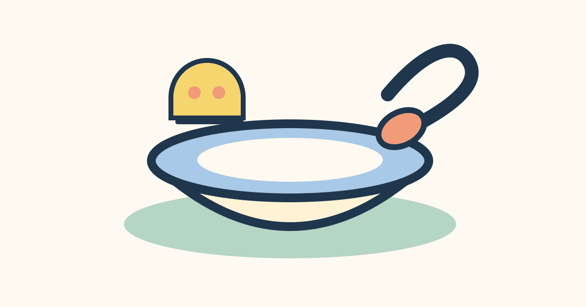 A small spoon beside a stable bowl and a soft food shape on a place mat