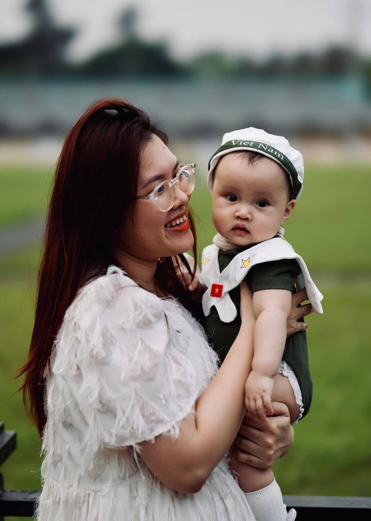 A mother holding her baby outdoors