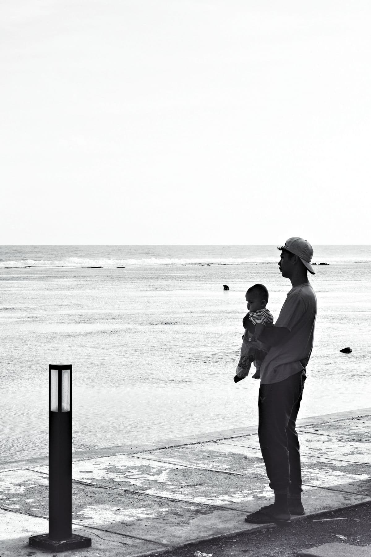 A father holding a child by the sea