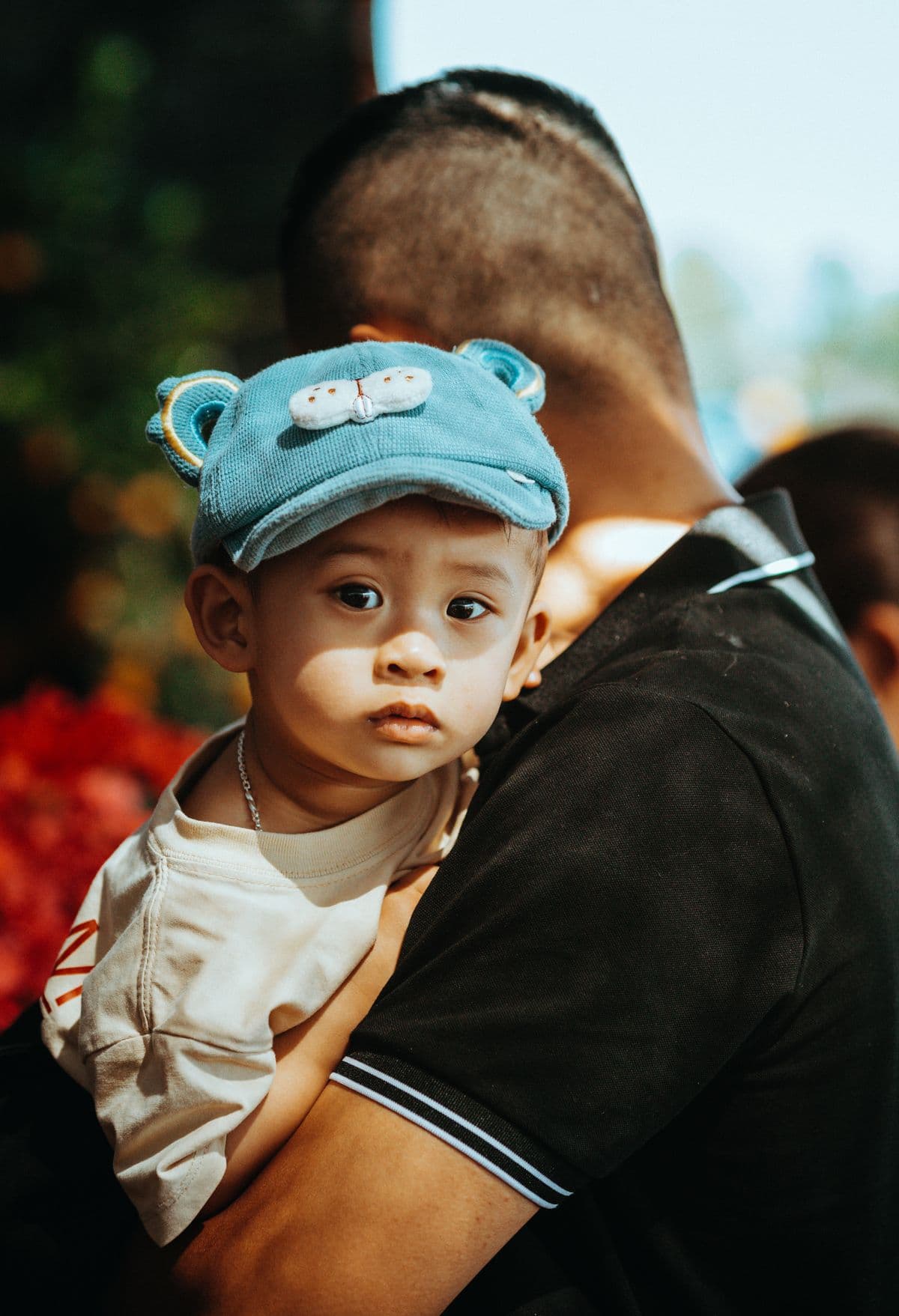 A father carrying a young child outdoors