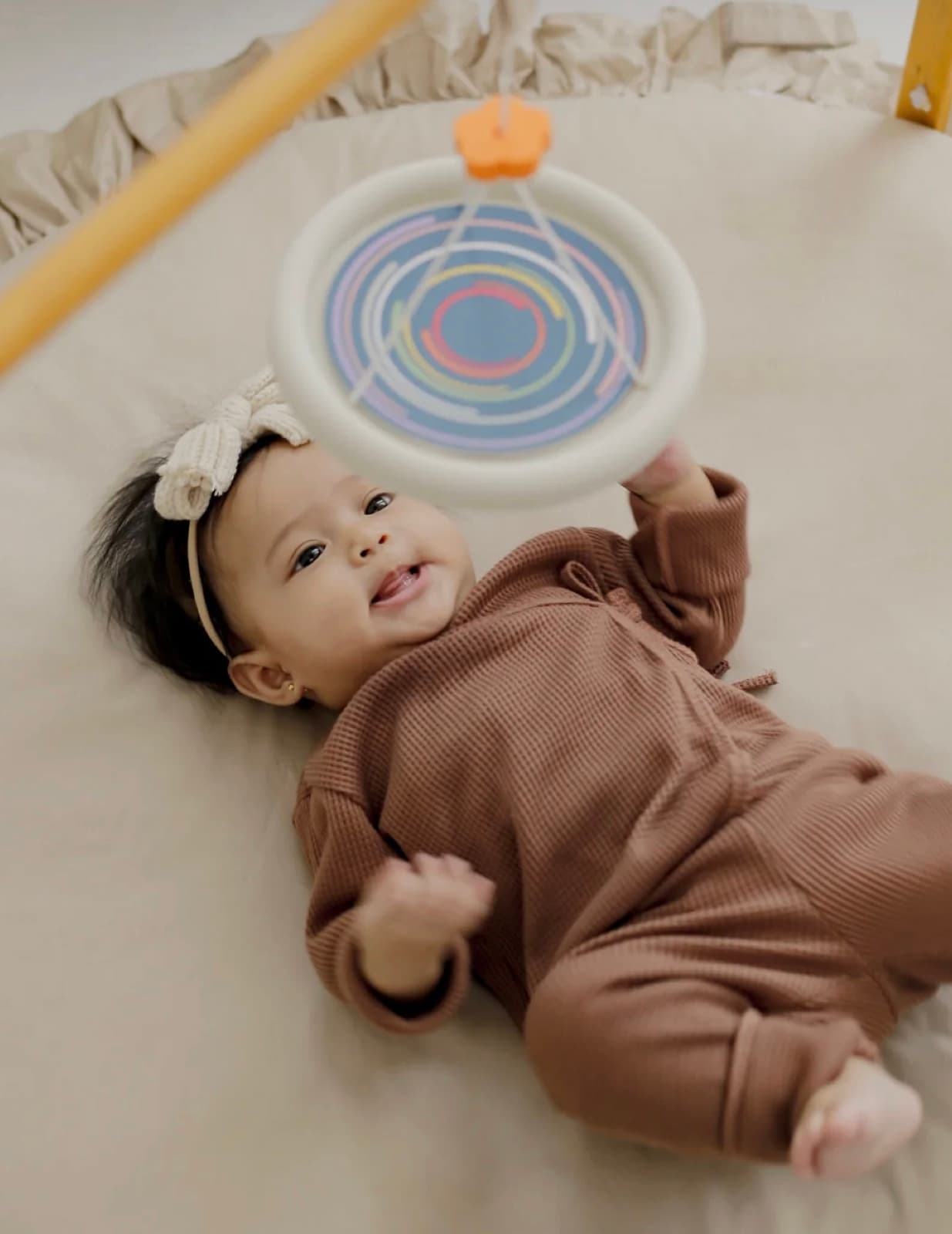 A baby reaching for a toy during play time